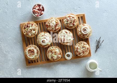 mini porzioni di flammekueche, o tarte flambee, specialità francese e tedesca, sulla griglia di raffreddamento in legno, vista dall'alto Foto Stock