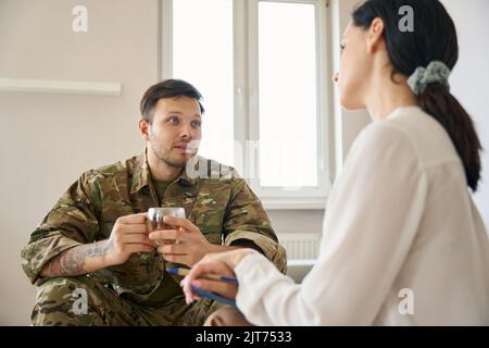 Giovane soldato comunica con una psicologa donna Foto Stock