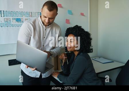 Uomo e donna amichevoli che lavorano a un progetto comune Foto Stock