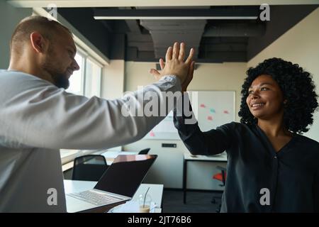 Colleghi di successo che danno cinque per la vittoria del progetto in carica Foto Stock