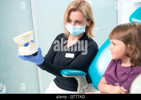 Medico esperto insegnando tecnica di spazzolatura della bambina Foto Stock