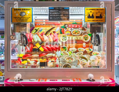 tokyo, giappone - agosto 06 2022: Gru giapponese chiamata anche UFO Catcher piena di detentori chiave raffiguranti realistics sushi e ramen noodles ciotole in un Foto Stock