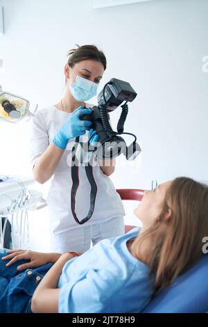 Dentista pediatrico che scatta foto dei denti del paziente Foto Stock