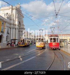 Tram aka Streetcar aka Trolley in Praha do Comércio (Piazza del Commercio) Lisbona, Portogallo. Arco da Rua Augusta Arch a sinistra Foto Stock