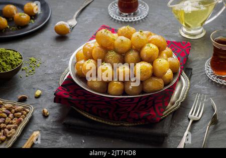 Cucina araba; dessert tradizionale mediorientale/Ramadan 'Zalabya', o Luqmat al-Kadi servito con miele e pistacchio. Foto Stock