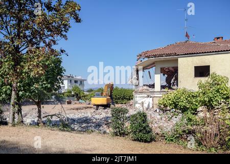 Casa di lavoro di demolizione. Casa di demolizione escavatore per un nuovo progetto di costruzione. Foto Stock