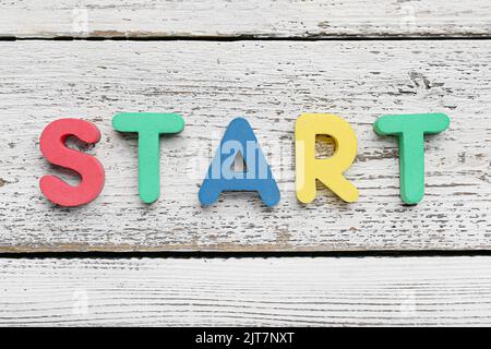 INIZIO parola su sfondo di legno bianco Foto Stock