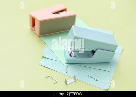Cucitrici, note adesive e graffette su sfondo a colori Foto Stock