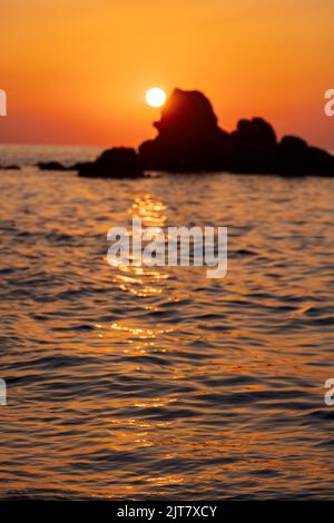 Splendida vista sul mare arancione tramonto con rocce in Italia. Paesaggio tropicale e colorato all'alba. Paesaggio naturale. Costa tropicale Foto Stock