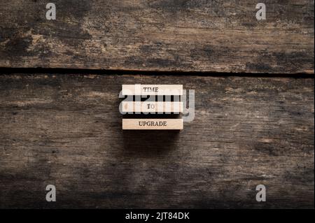 Tempo di aggiornare il segno scritto su tre pioli di legno collocati su rustici tavole di legno. Vista dall'alto. Foto Stock