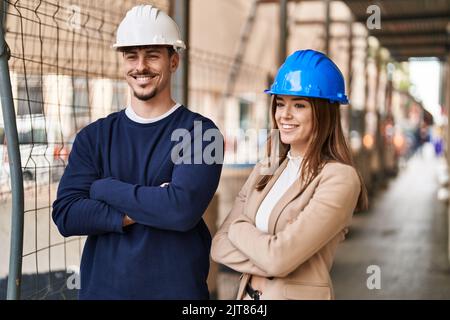 Mando e donna architetti sorridenti fiduciosi in piedi con braccia incrociate gesto di strada Foto Stock