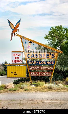 Lo storico moderno cartello al neon di metà secolo sulla strada per Cassie's Bar and Lounge a Cody, Wyoming. Il segno per il club cena offre bistecche, pollo, Foto Stock