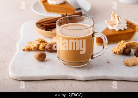 Caffè speziato di zucca su un asse di marmo, bevanda calda stagionale per l'autunno Foto Stock