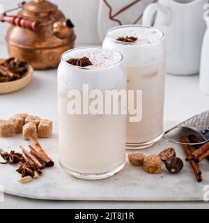 Latte di chai ghiacciato con spezie invernali calde sormontato da schiuma di latte Foto Stock