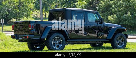 Un nuovo SUV nero Jeep Gladiator convertibile in vendita presso una concessionaria in una giornata di sole estate Foto Stock