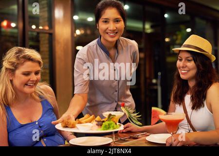 Viene servita la cena. Ritratto di una cameriera che serve i clienti in un ristorante. Foto Stock