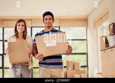 Infine, l'ultima delle scatole. Ritratto di una giovane coppia sorridente che trasporta le scatole nel giorno in movimento. Foto Stock
