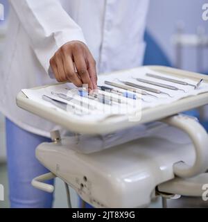 Preparare gli strumenti per la prossima consultazione. Primo piano di un dentista irriconoscibile che lavora con un vassoio di strumenti chirurgici. Foto Stock