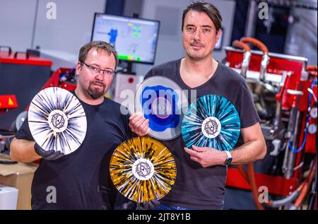 22 agosto 2022, Meclemburgo-Pomerania occidentale, Güstrow: Andre Kronert (r), e Daniel Slabschie (l), amministratore delegato della società discografica 'materia di fatto', mostrano alcuni dei dischi colorati pressati nella società. L'impresa con attualmente cinque colleghi produce per alcune settimane in un ex clamoroso patata che ha dovuto essere convertito complessamente per la produzione di dischi. Con una forza di 150 tonnellate, i dischi di lunga durata sono prodotti sulle presse a 200 gradi Celsius da cloruro di polivinile (PVC). Ogni anno devono essere premuti tra 250.000 e 300.000 record. Secondo il Ger Foto Stock