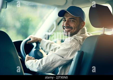 OFF per fare l'ultima consegna per il giorno. Ritratto di un addetto alla consegna che guida nel suo furgone. Foto Stock