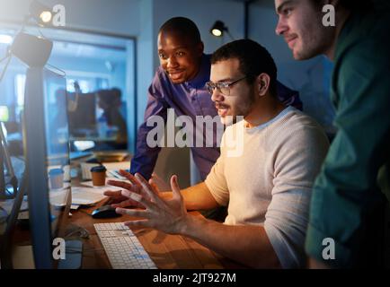 Si tratta di un'esperienza entusiasmante. Un team di giovani uomini d'affari che lavorano tardi in ufficio. Foto Stock