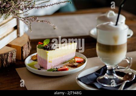 Un pezzo di cheesecake e un bicchiere di caffè ghiacciato Foto Stock