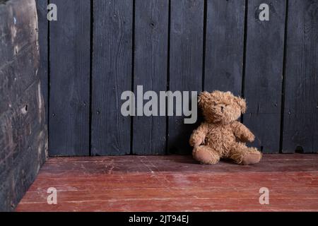 l'orsacchiotto si trova nella camera da letto nell'angolo del pavimento in legno, l'orsacchiotto si trova sul pavimento della casa Foto Stock
