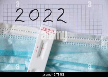 Test negativo per il covid si trova su una maschera medica su un notebook con il testo 2022, un test anticorpale Foto Stock