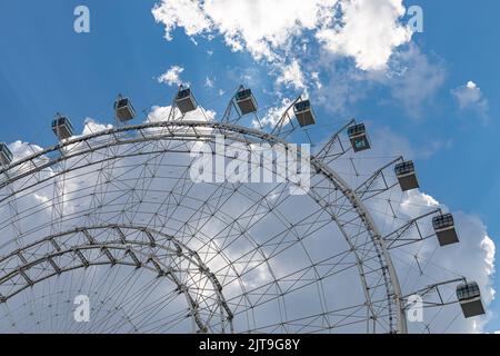 frammento di ruota ferris cabine senza persone. ruota ferris in un parco divertimenti contro il cielo blu Foto Stock