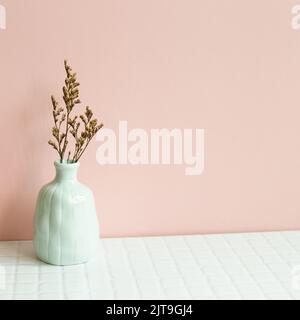 Arredamento interno casa, vaso di pianta secca su tavolo bianco. Sfondo parete rosa Foto Stock