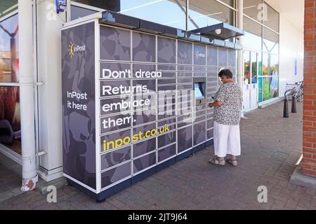 Donna controlla InPost a Polish Logistic Services business drop off Collect Return Invia pacco automatico Tesco parcheggio Tiptree Essex Inghilterra UK Foto Stock