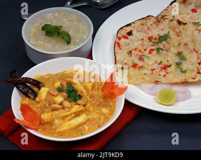 Un primo piano di un korma di Shahi Paneer servito con naan di kashmiri e zuppa di mais dolce Foto Stock