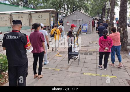 I residenti che si accingono a fare la fila per i test degli acidi nucleici su strada sotto la politica cinese di zero covid Foto Stock