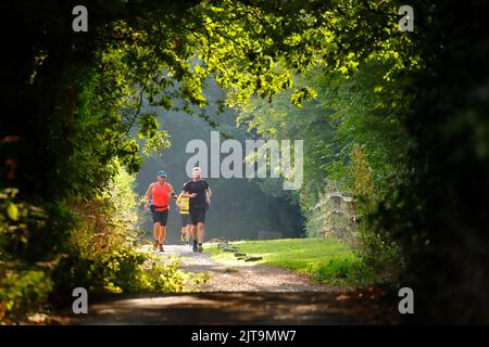 Persone che fanno jogging lungo la strada a Swillington, Leeds, West Yorkshire, Regno Unito Foto Stock