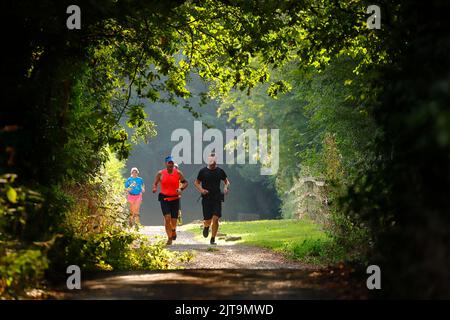 Persone che fanno jogging lungo la strada a Swillington, Leeds, West Yorkshire, Regno Unito Foto Stock