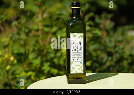 Umea, Norrland Svezia - 8 agosto 2022: Una bottiglia di vetro svedese di olio extra vergine di oliva su un tavolo Foto Stock