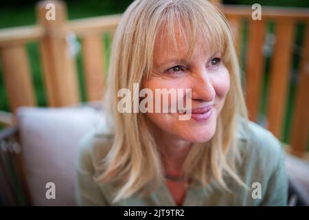 Felice donna matura rilassarsi in terrazza in estate. Foto Stock