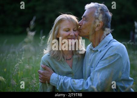 Ritratto di coppia anziana affettuosa baciata in natura. Foto Stock
