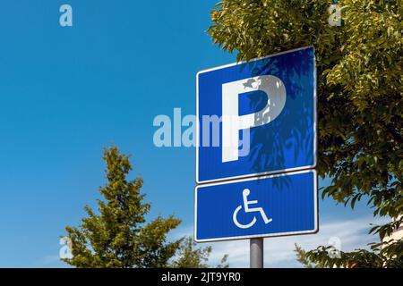 Cartello posto auto riservato, persone disabili con disabilità in pittogramma sedia a rotelle, focus selettivo Foto Stock