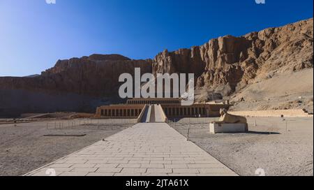 Veicolo pubblico giallo che sposta i turisti all'ingresso principale del Tempio mortuario di Hatshepsut vicino a Luxor, Egitto Foto Stock