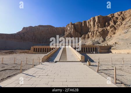 Veicolo pubblico giallo che sposta i turisti all'ingresso principale del Tempio mortuario di Hatshepsut vicino a Luxor, Egitto Foto Stock