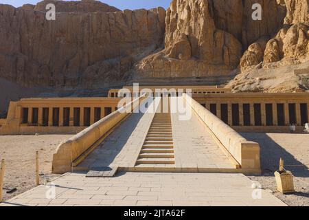 Veicolo pubblico giallo che sposta i turisti all'ingresso principale del Tempio mortuario di Hatshepsut vicino a Luxor, Egitto Foto Stock