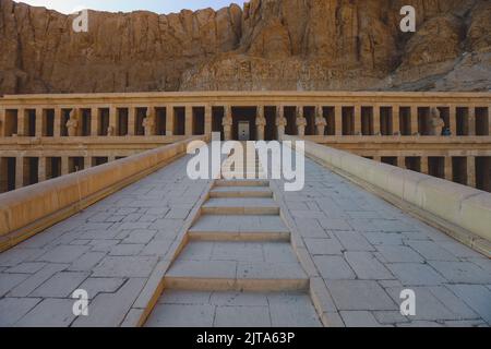 Veicolo pubblico giallo che sposta i turisti all'ingresso principale del Tempio mortuario di Hatshepsut vicino a Luxor, Egitto Foto Stock