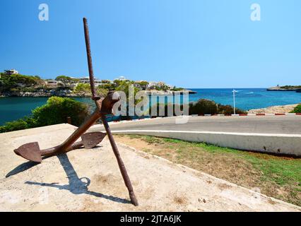 Vista grandangolare di una grande ancora di ferro vicino al porto della città di Porto Cristo nell'isola di Maiorca, Spagna. Foto Stock
