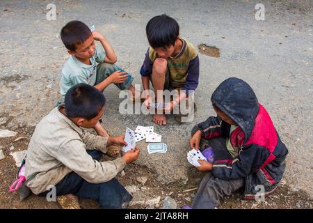 Vietnam, i ragazzi della tribù Hmong nera giocano le carte sulle camicie di Sapa. Sapa è una città vicino al confine cinese e popolare dai turisti a causa della scen Foto Stock