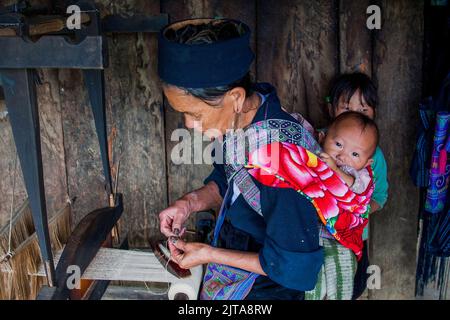 Vietnam, la tribù nera Hmong donna è tessendo canapa in un villaggio vicino Sapa.Sapa è una città vicino al confine cinese e popolare dai turisti a causa del Foto Stock