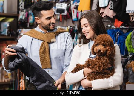 Uomo arabo con giacca animale vicino alla ragazza con barzelletta nel negozio di animali domestici Foto Stock