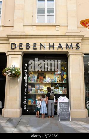 Il grande magazzino Debenhams, ora chiuso, circonda il negozio di giocattoli My Small World in St Lawrence Street, Bath Foto Stock