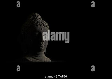Statua della testa di Buddha con una spettacolare illuminazione a basso tasto Foto Stock