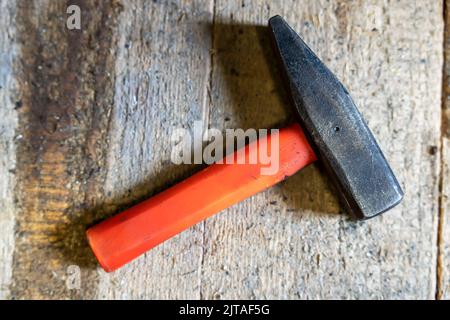 martello in officina con manico corto in plastica su fondo in legno Foto Stock